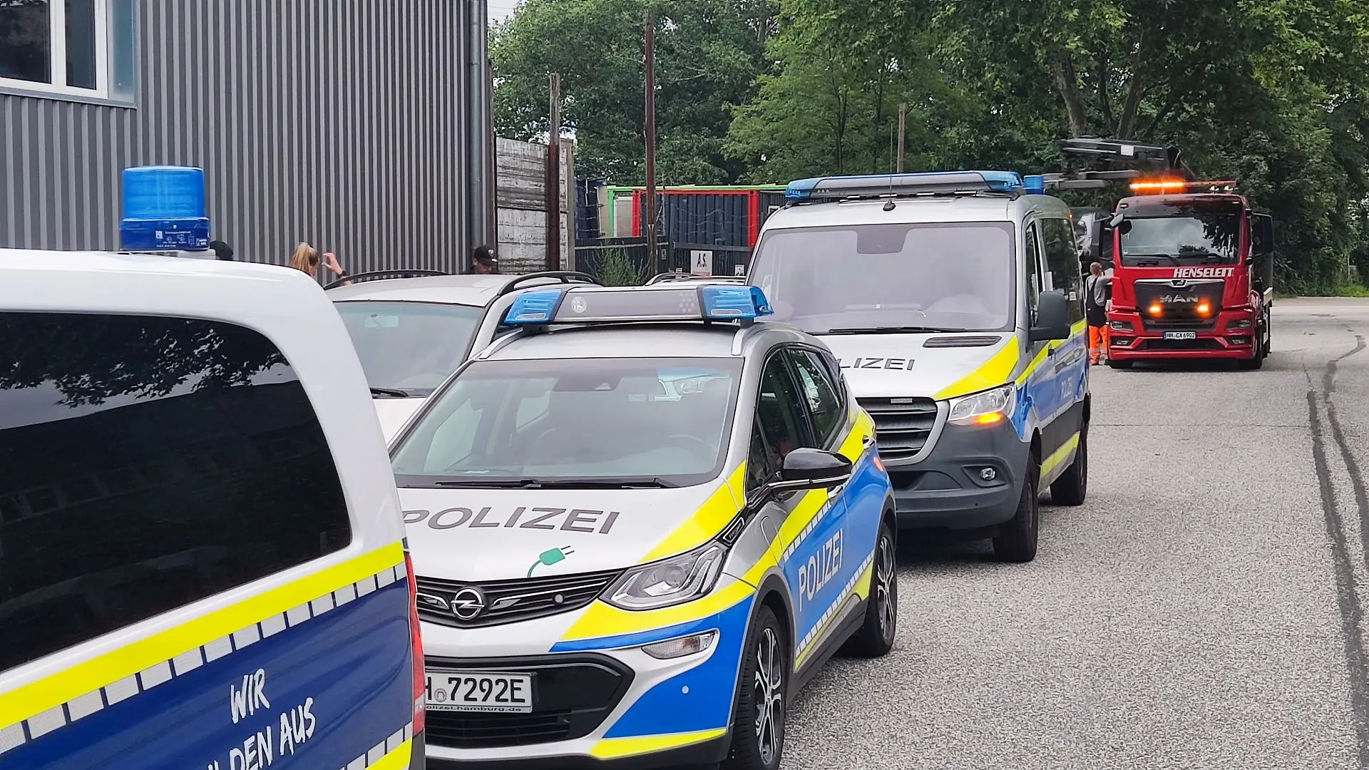 Polizeifahrzeuge stehen hintereinander, im Hintergrund ein roter LKW