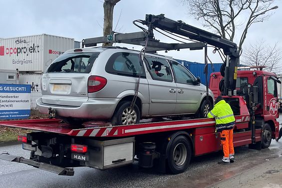 Ein beschädigtes PKW wird auf einen LKW geladen.