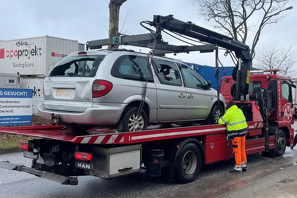 Ein beschädigtes PKW wird auf einen LKW geladen.
