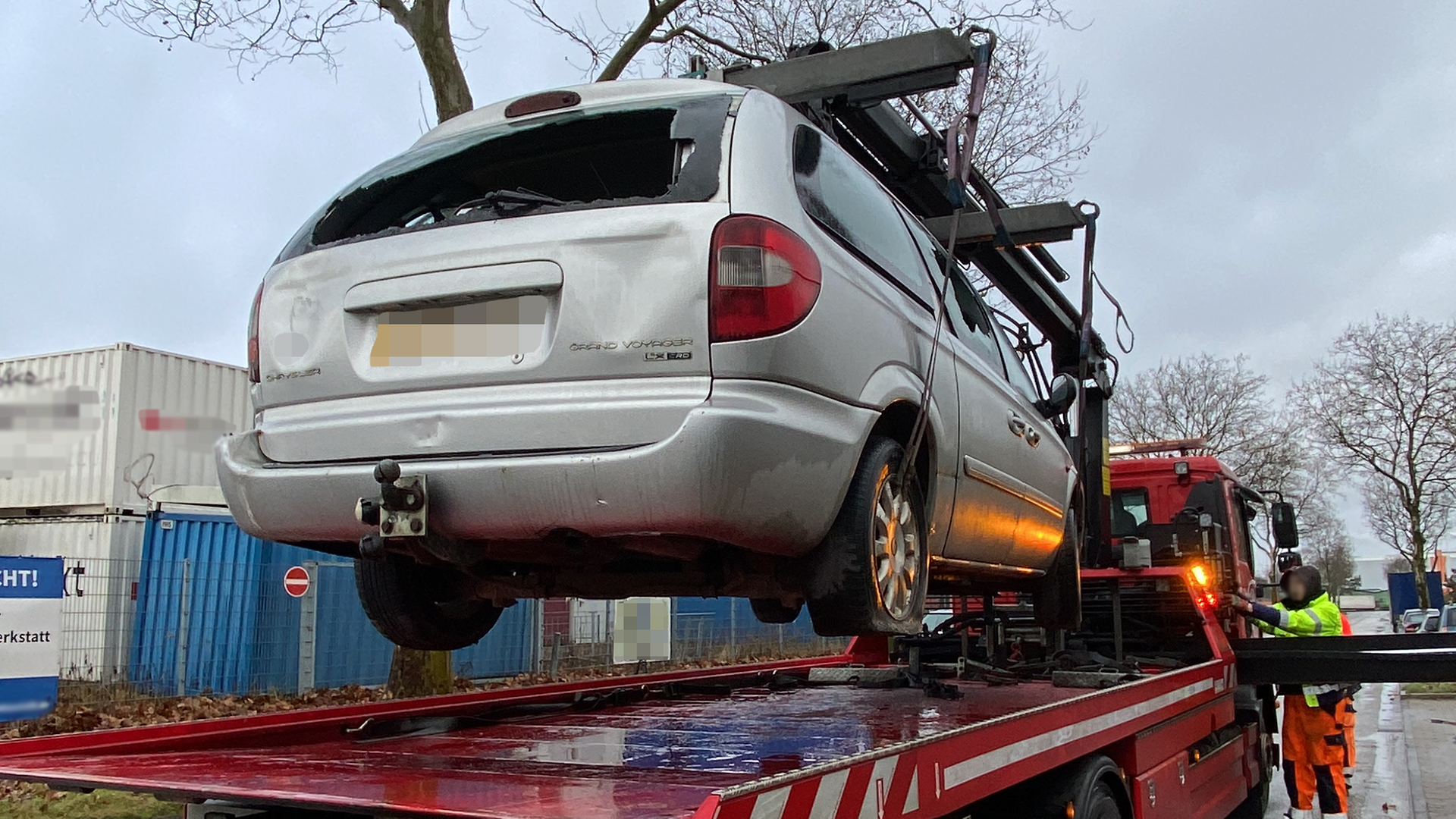 Ein beschädigtes PKW wird auf einen LKW geladen.