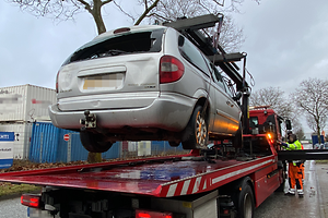 Ein beschädigtes PKW wird auf einen LKW geladen.